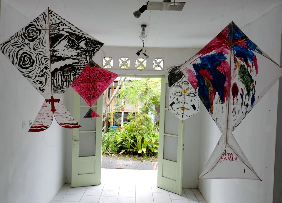 Painted kites hanging in a white room