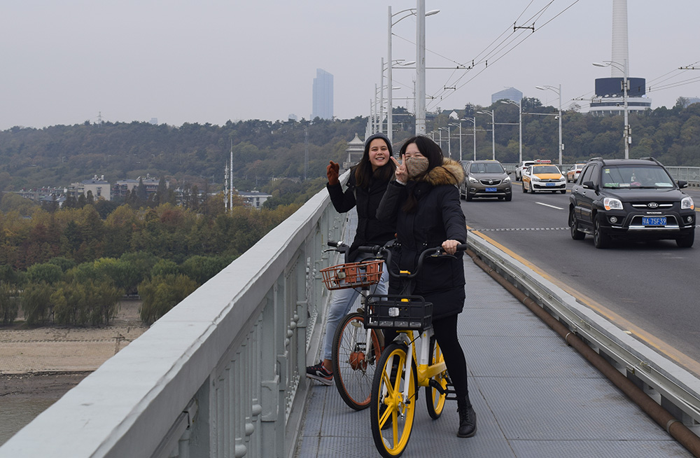 Emily Wibly and a friend sitting on bikes on a highway overpath