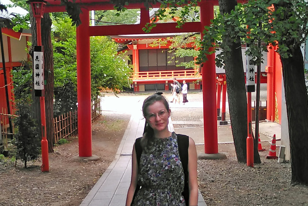 Kina standing in front of a torii gate at at temple in Tokyo