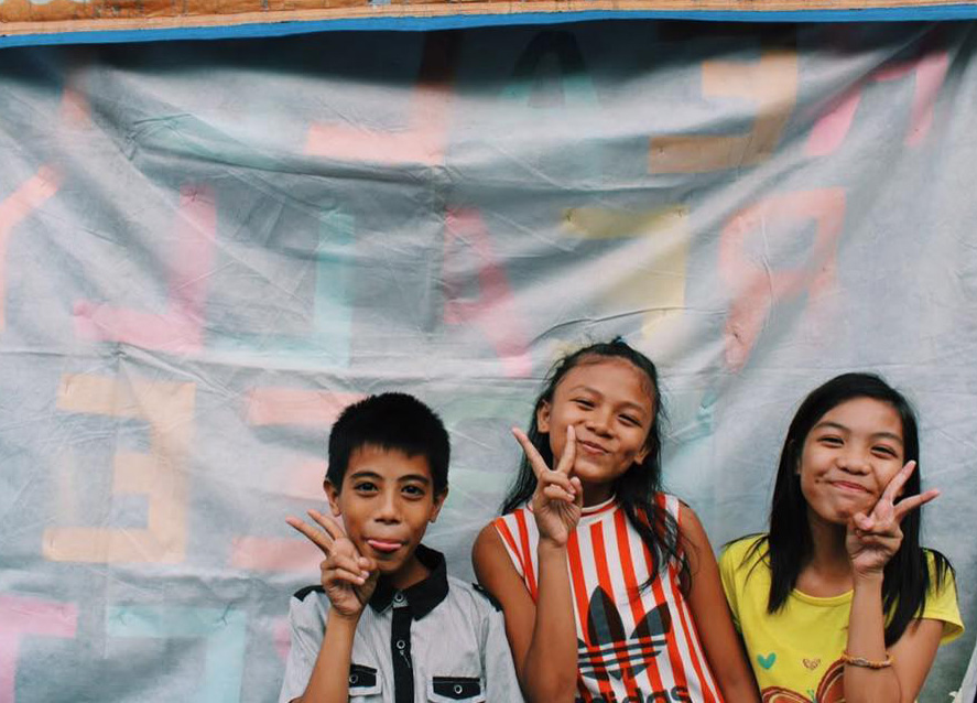 Three Manila kids laughing to camera