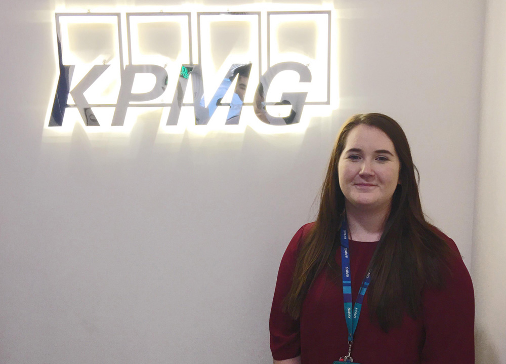 paige standing in front of a KPMG sign