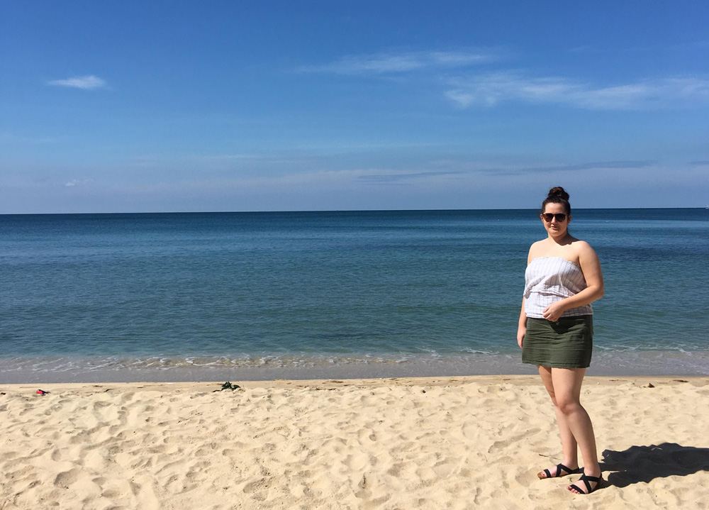 Paige standing on a white sand beach