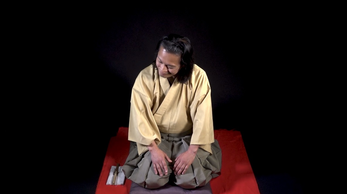 Hiroshi kneeling on a mat wearing traditional Japanese clothing