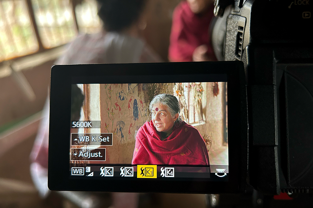 An image looking through the viewfinder of a camera which is trained on woman wearing a red shawl 