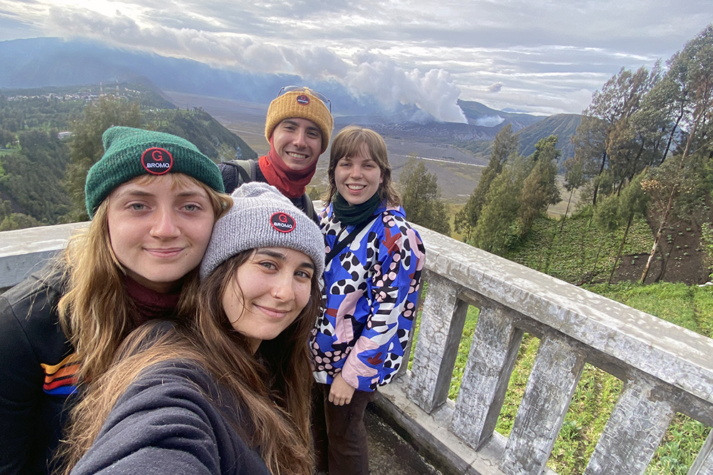Isabella taking a selfie with three friends with a view of hills and forest behind them