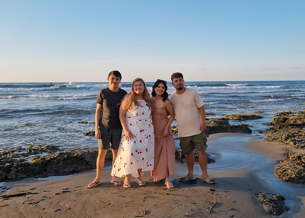 Krychelle standing on a beach with her bother and cousins