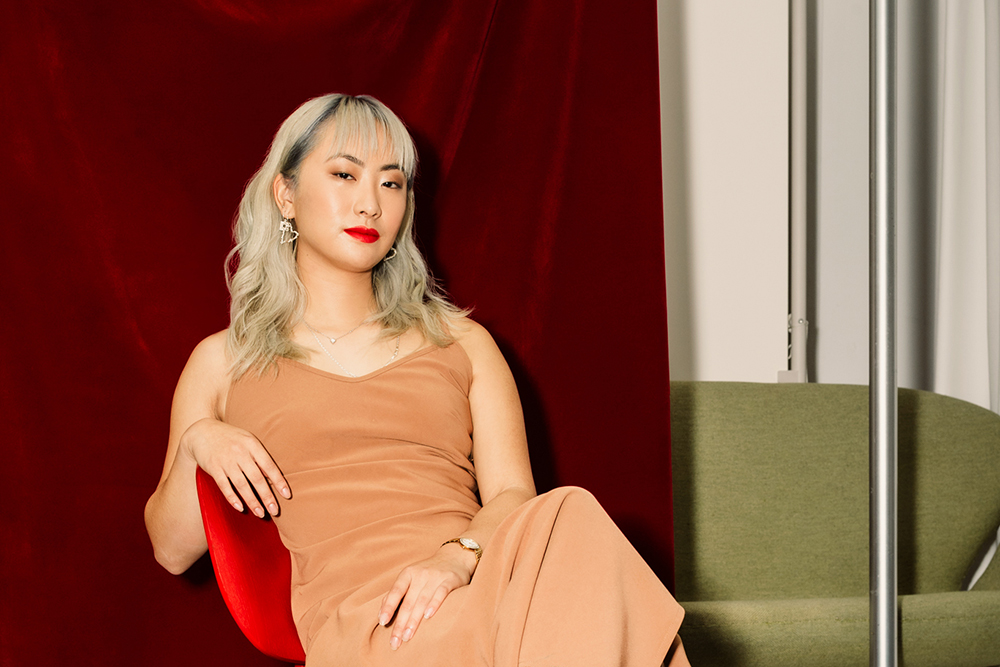 Nahyeon Lee sitting on a chair wearing a brown dress