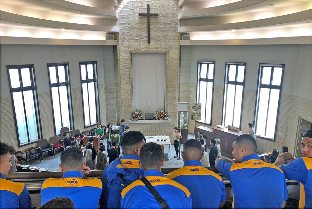 A view looking over the shoulders of Saint Peter's College students into the transept of a church