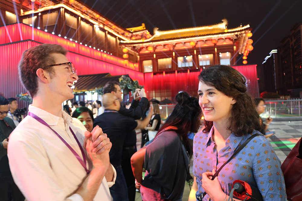 Two Leadership Network members standing in front of a traditional style Chinese building lit up by lights