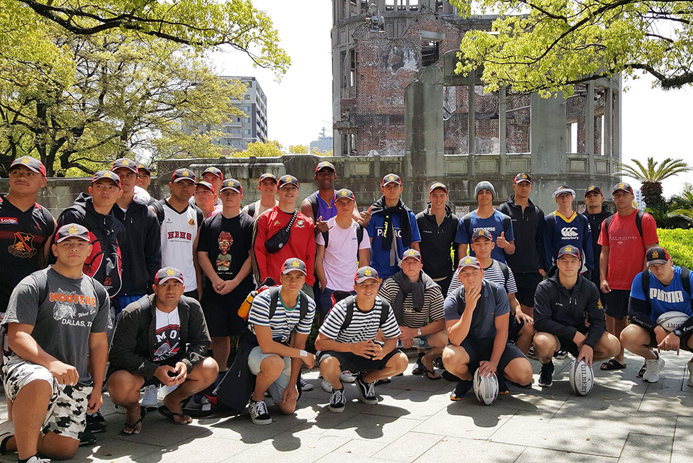 The team crouching down in front to the Genbaku Dome in Hiroshima