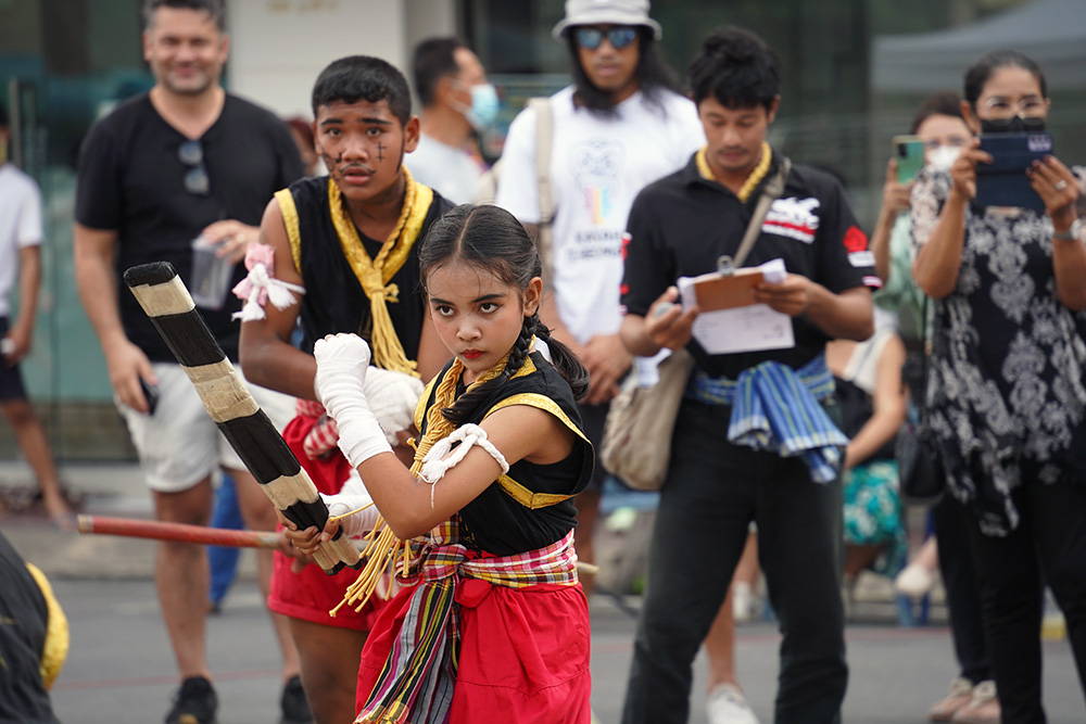 A girl in traditional costume displaying her muay Thai skills