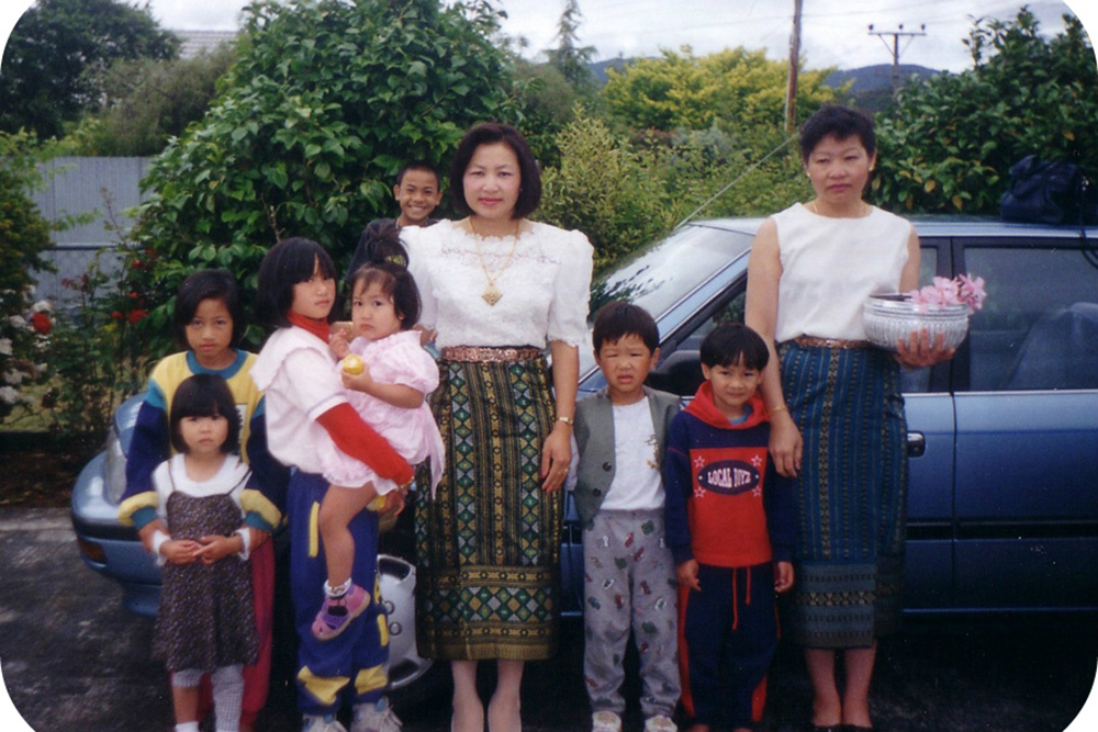 A family from Laos standing in front of their car in Wainuiomata