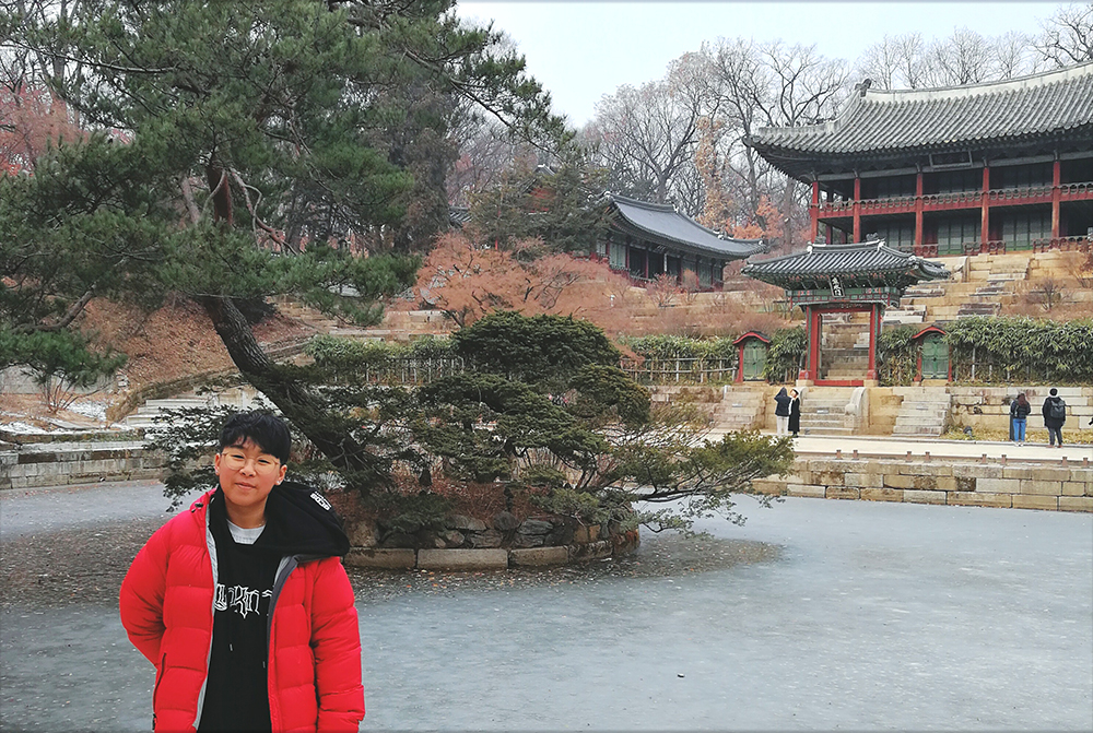 Pang standing outside in front of a traditional Korean building