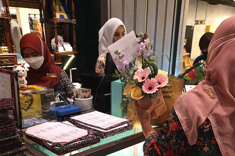 A woman buying flowers from a store