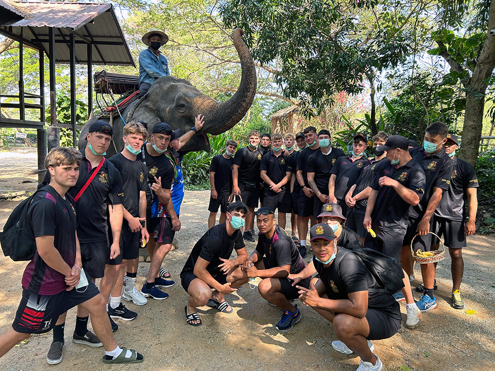 Hamilton Boys High rugby players posing for a group photo with an elephant