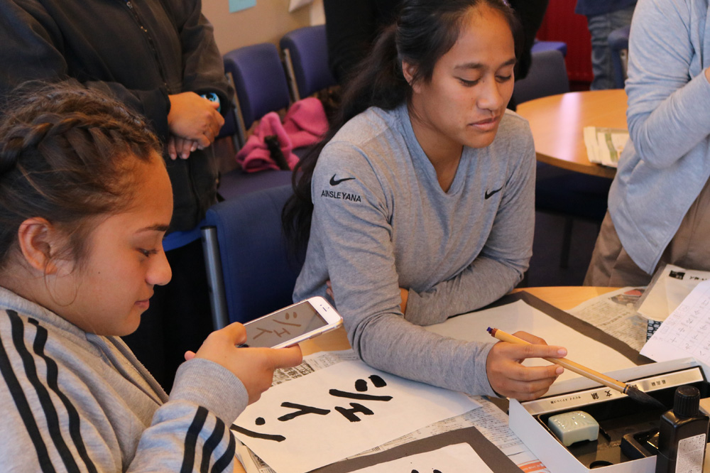 Member of the St Marys Sevens team learn about calligraphy