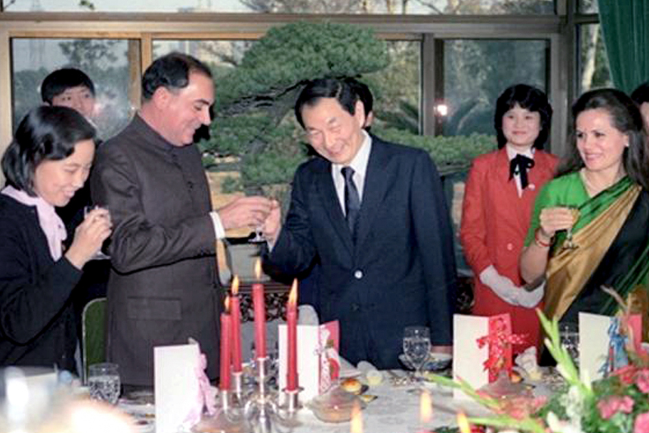 Two men shaking hands in the middle of a dinner party with onlookers