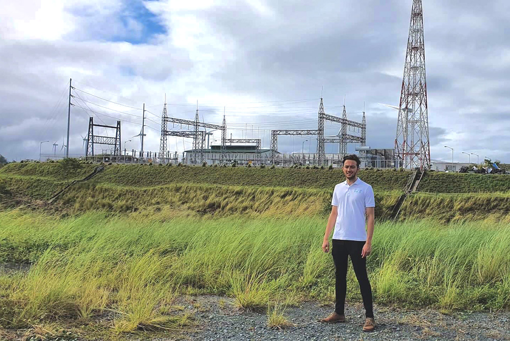 Callum standing in front of a power station