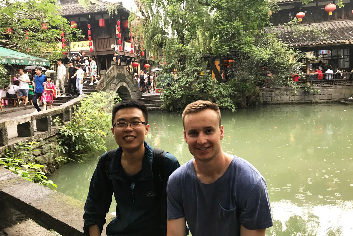Jack and a colleague sitting in front of a pond in a traditional-style Chinese garden
