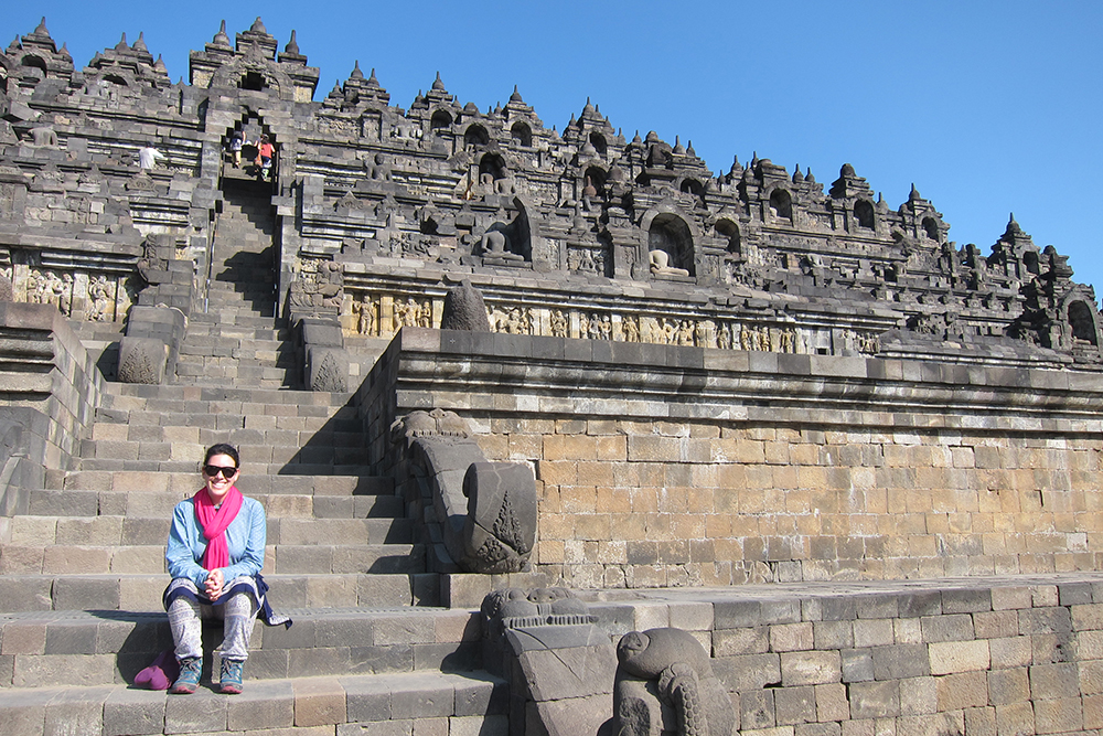 Caire sitting on steps at at Borobudur temple in Indonesia 