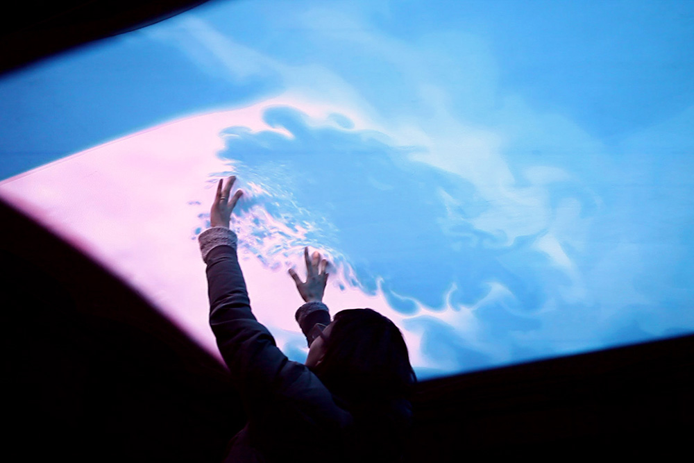 A child creating patterns in the Cloud Pink installation