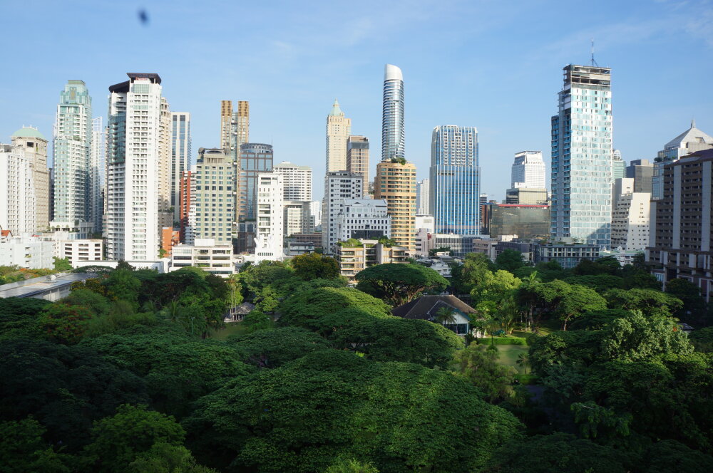 A photo of the skyline of Bangkok showing modern skyscrapers and forest