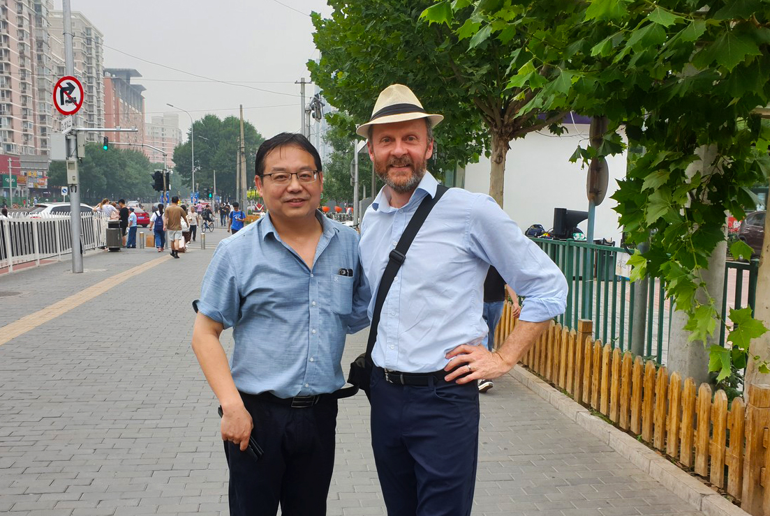 John standing with Dr Huang Ning on a street
