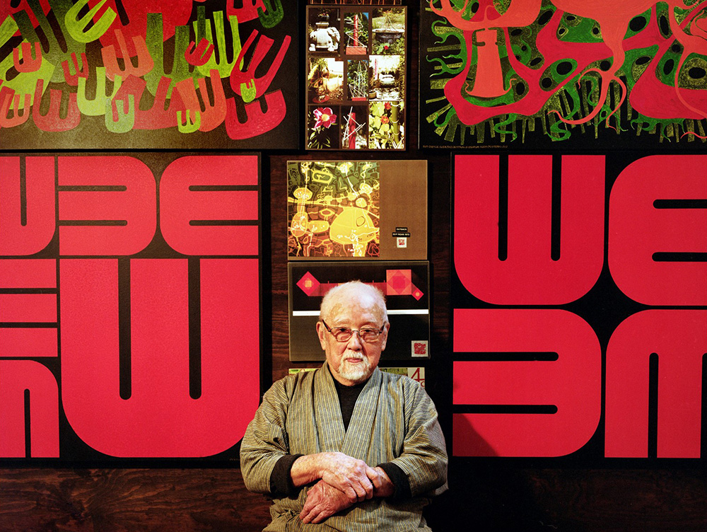 Guy Ngan sitting in front of East Meets West imagery
