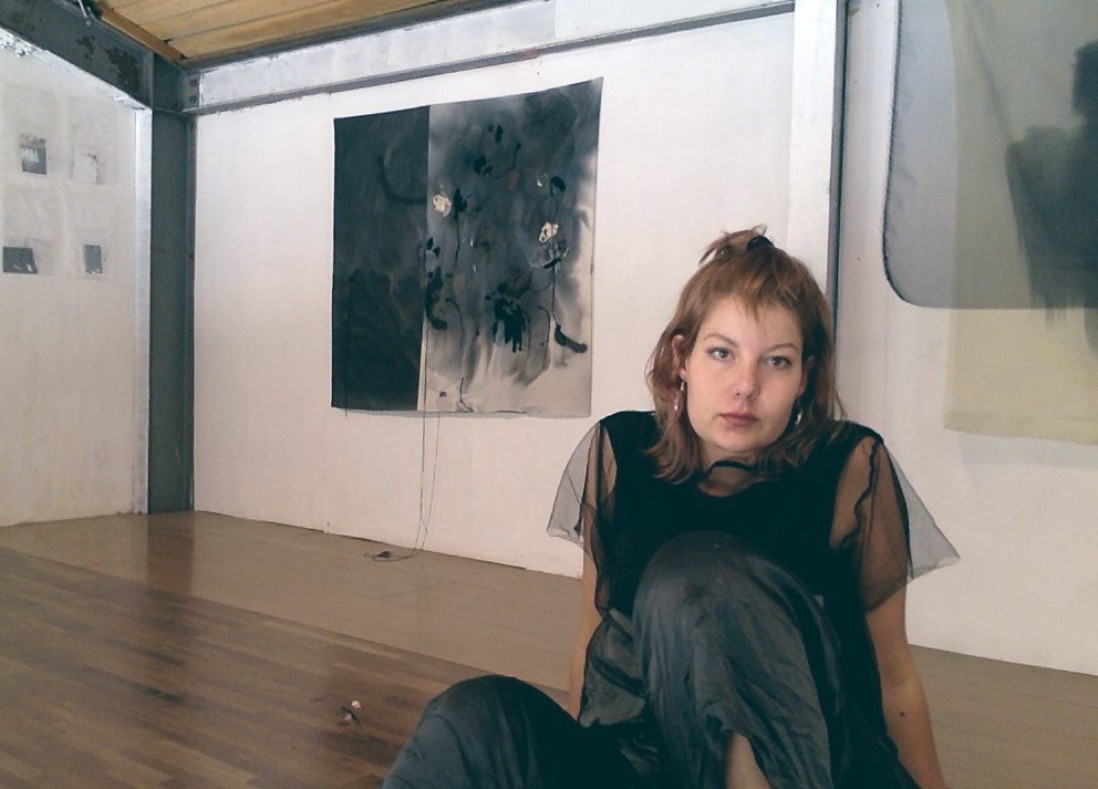 Ella sitting on the ground in an art gallery