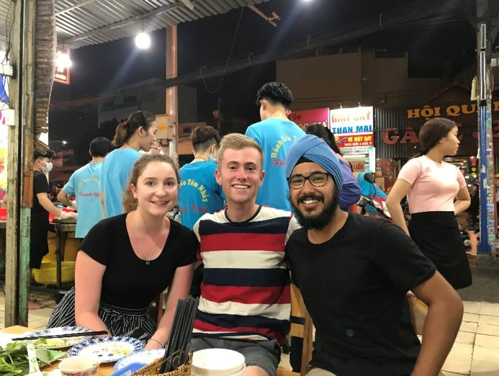 Ethan (centre) with fellow interns Keeley Farrell and Parneet Kohli eating dinner at a nightmarket