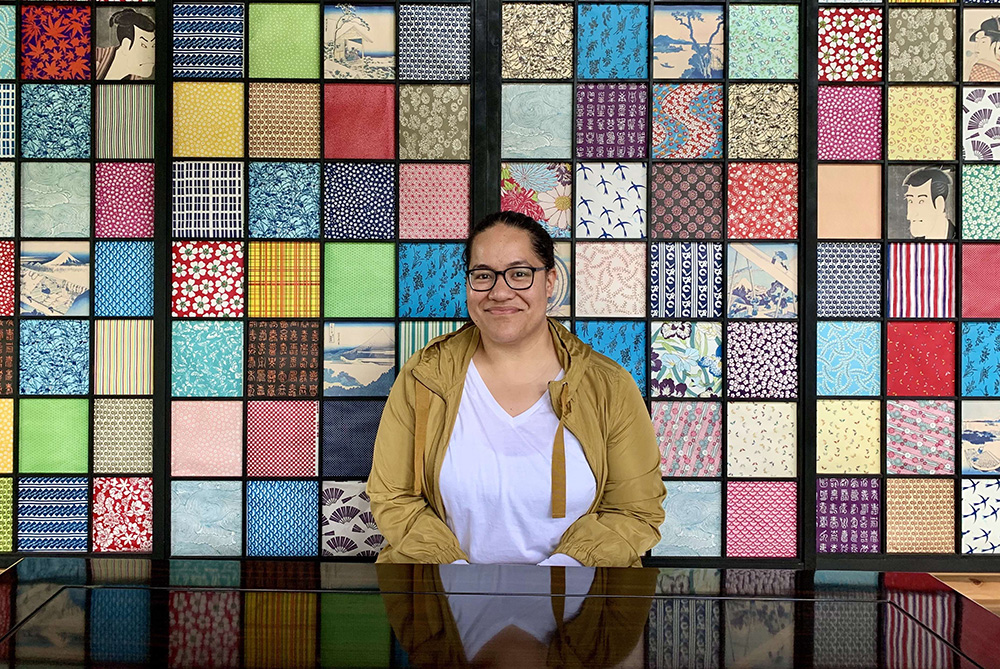 Leadership Network member Fine Lavoni Koloamatangi sitting in front of a brightly coloured wall patchwork squares