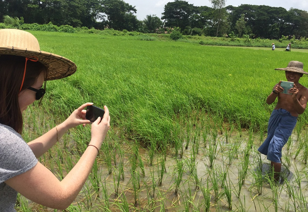 Fiona taking a photo of a man in a rice paddy as he takes a photo of her
