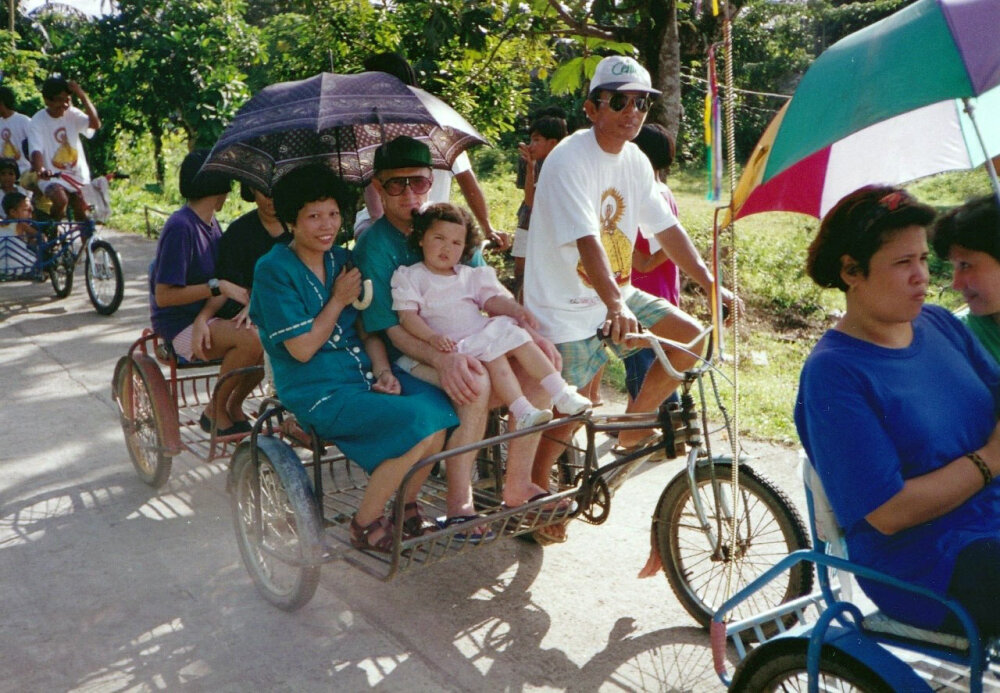 Justine as a young child riding with her parents in a bicycle sidecar