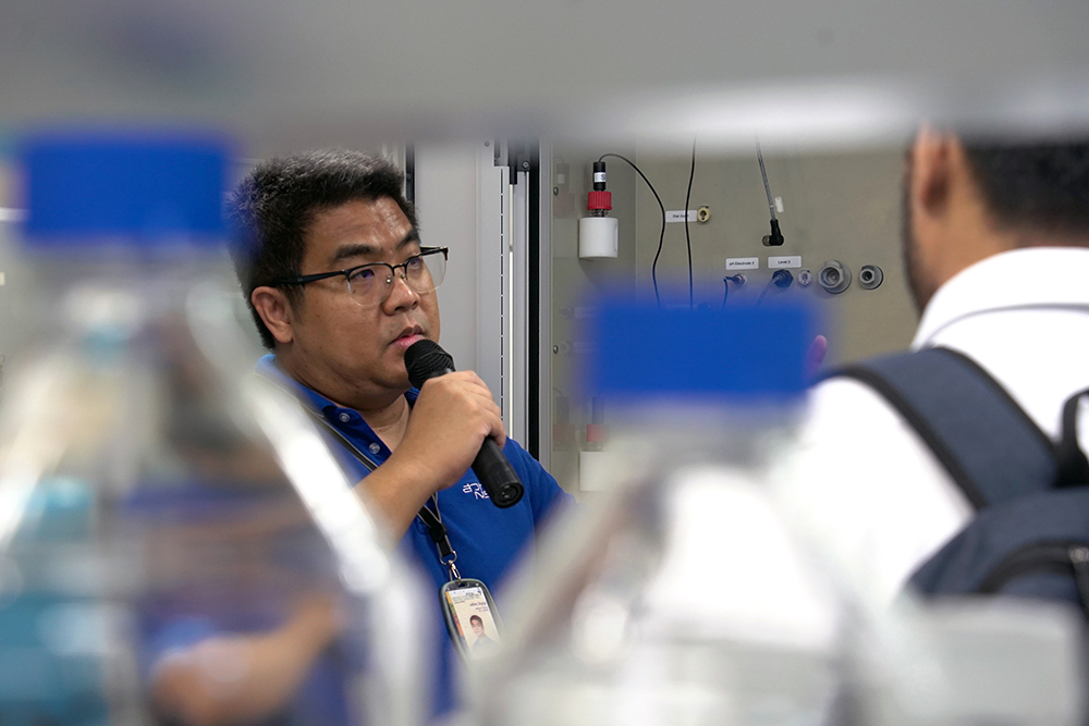 A man speaking into a microphone in a lab