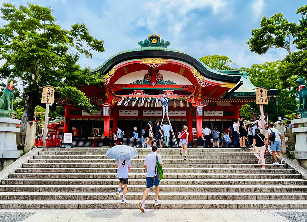 People walking up steps leading to Fushimi Inari Shrine