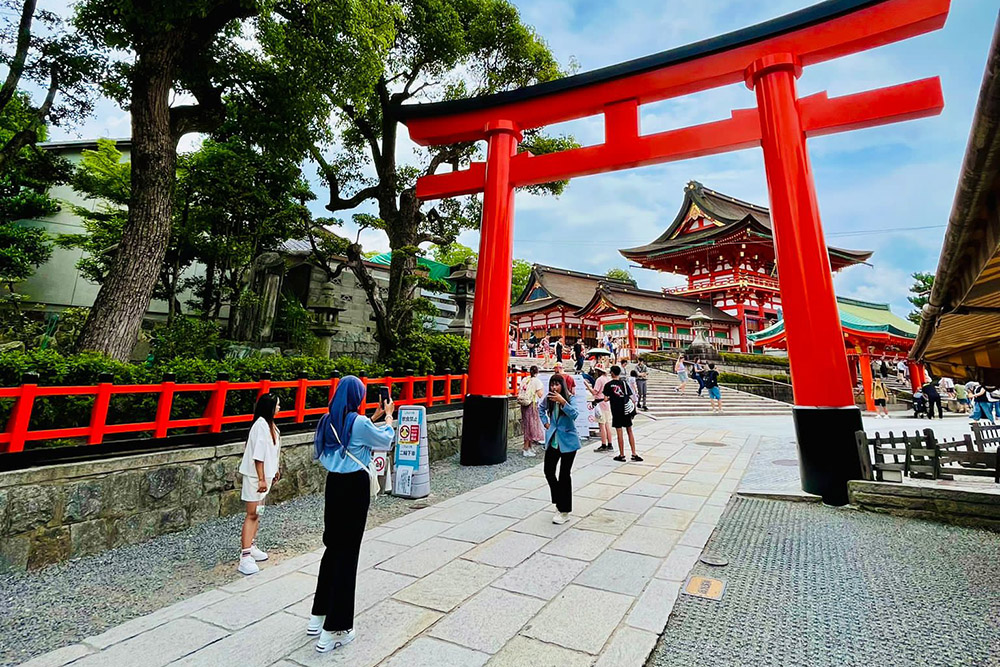 People walking through the gates to enter Fushimi Shrine