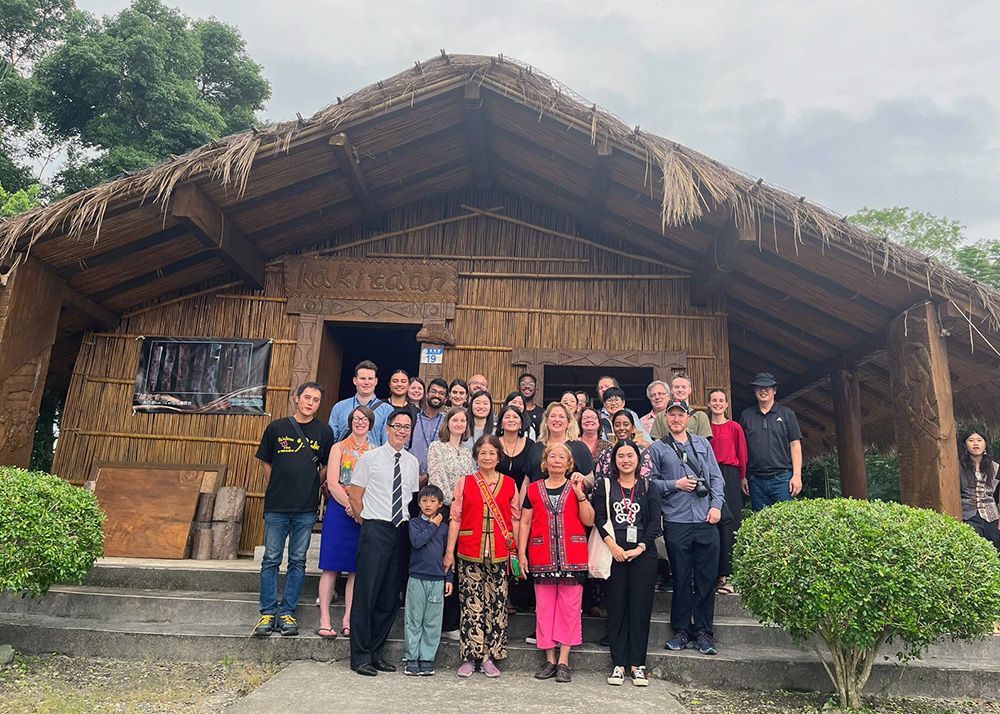 A group of LeadershipNetwork members standing outside a traditional kakitaan building with elders of the local indigenous tribe