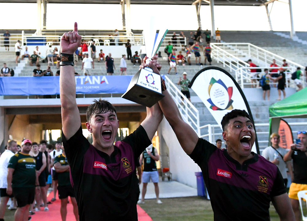 Two Hamilton Boys High School players holding up a trophy
