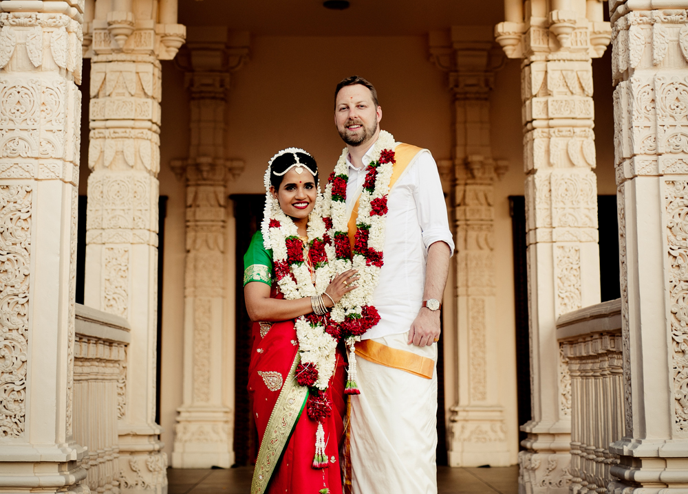 Wedded couple standing on the steps of a marble bilding