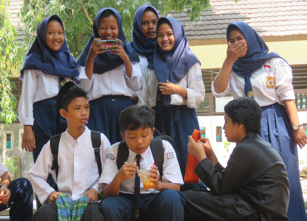 Indonesian school kids sitting eating lunch