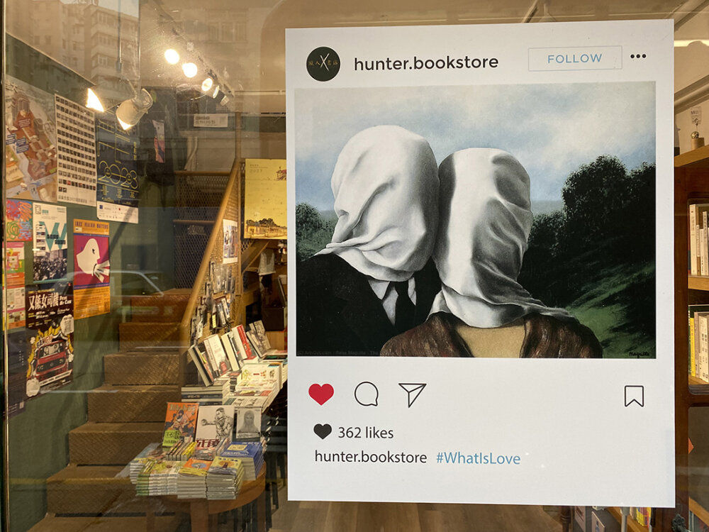 A poster in a bookstore window showing a man and a woman with white hoods over their faces