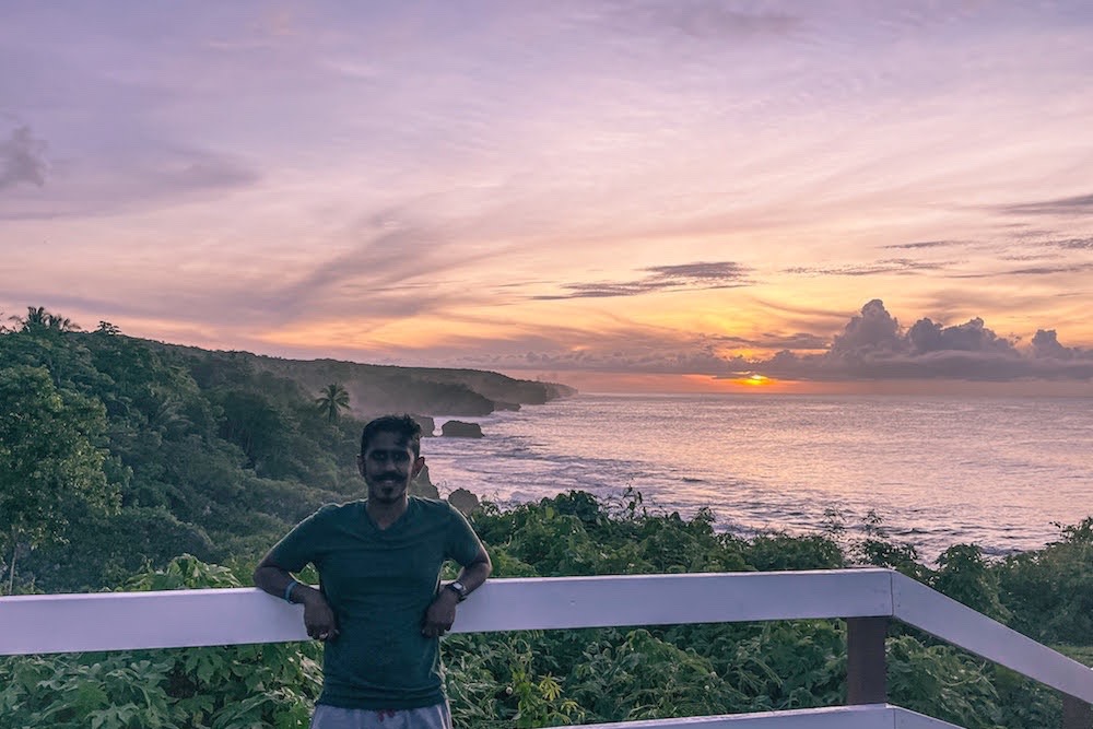 Ajay standing outside with a coastal panorama stretching away into the distance behind him