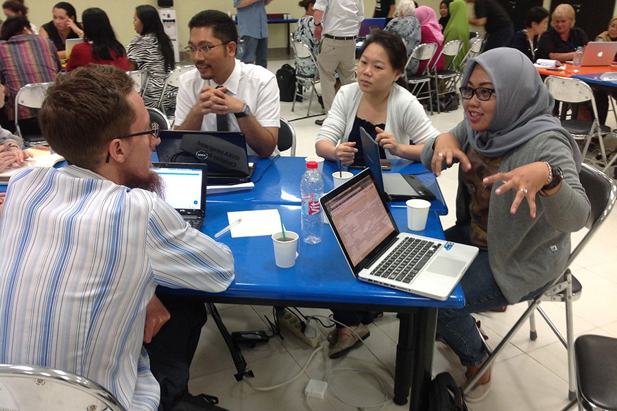A New Zealand teachers and their Indonesian counterpart talking at a table with colleagues
