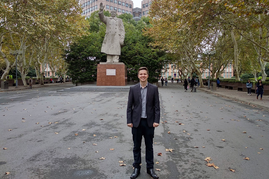 Jack Petterson standing in front of a statue of Chairman Mao