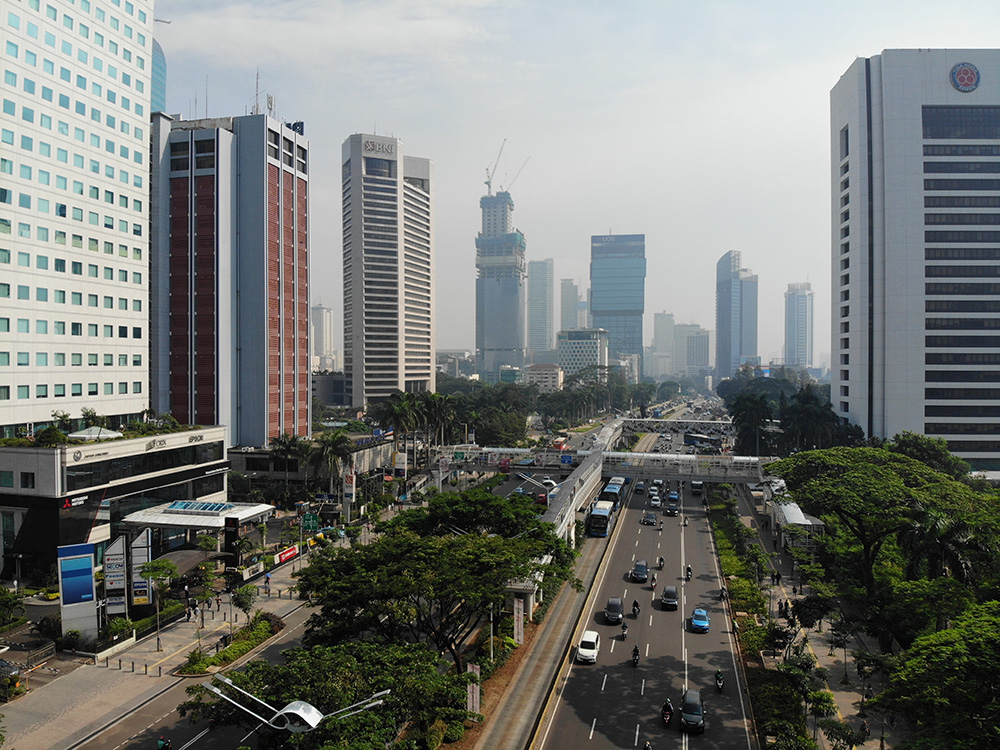 A shot looking down a freeway with tall buildings on either side