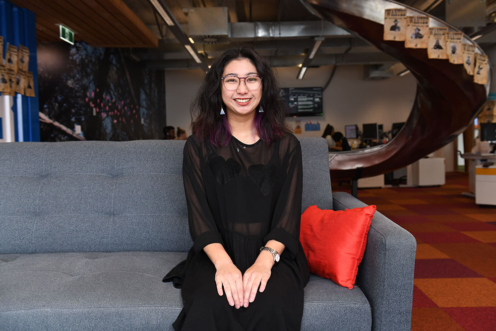 Jess Wong sitting on a couch in a foyer 