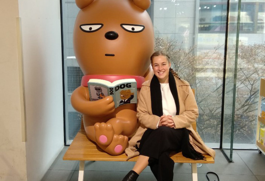 Kate sitting next to a large cartoon dog sculpture