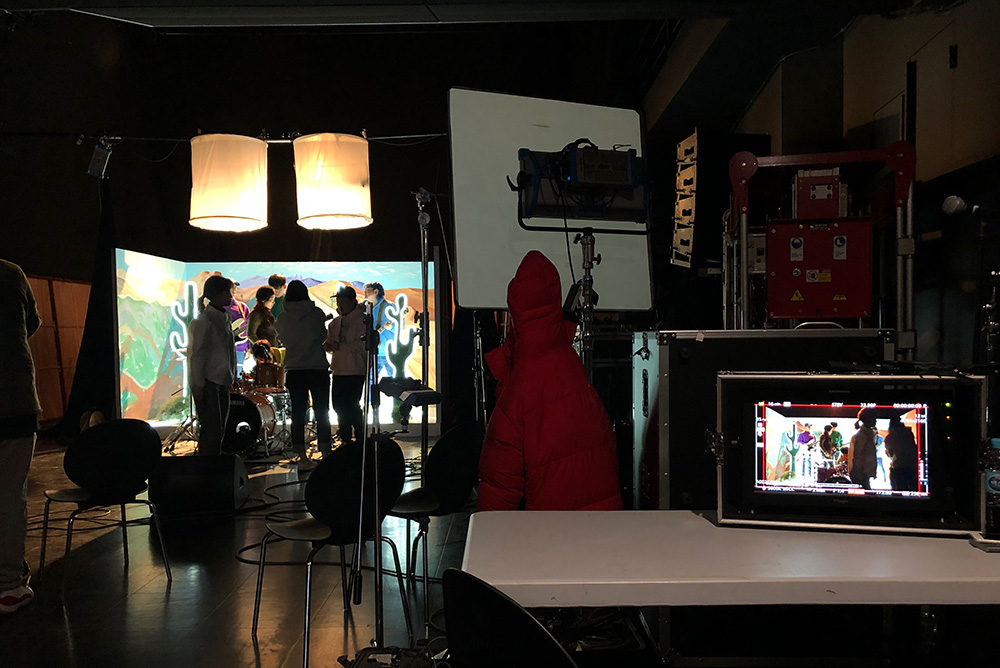 People on a set with a video monitor in the foreground
