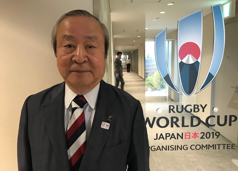 An official standing in front of the rugby world cup sign