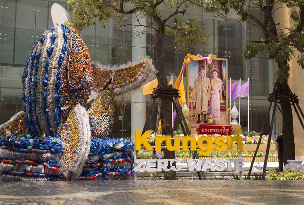A decorative display of tinsel adorns a large photo of the King of Thailand